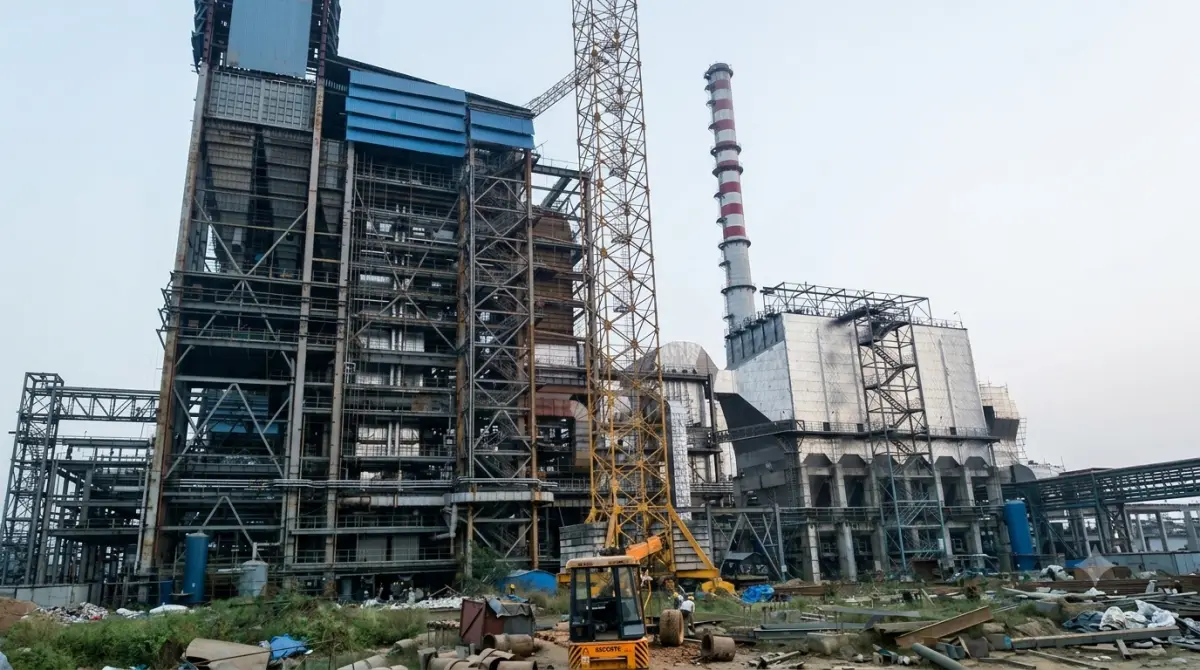 Plant overview — boiler structure, ducting and chimney with a tower crane in the middle of erection